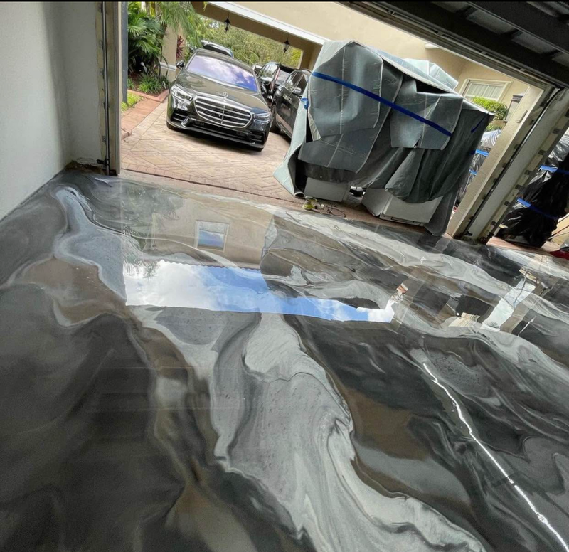 Black and silver marbled metallic epoxy garage floor with the door open