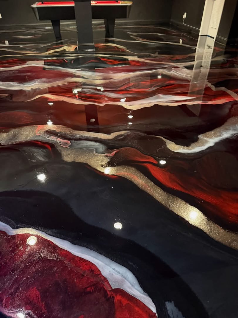 Red, black and gold metallic epoxy floor in a basement game room with a pool table