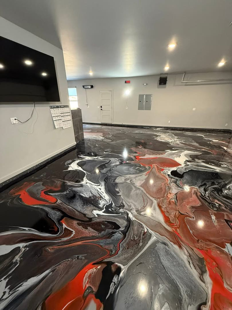 Black, silver and red metallic epoxy floor in a room with a wall-mounted TV