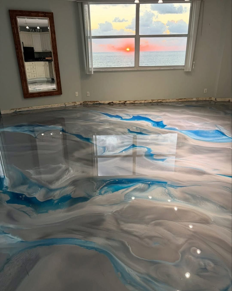 Blue and white ocean-style metallic epoxy floor in an oceanfront room at sunset