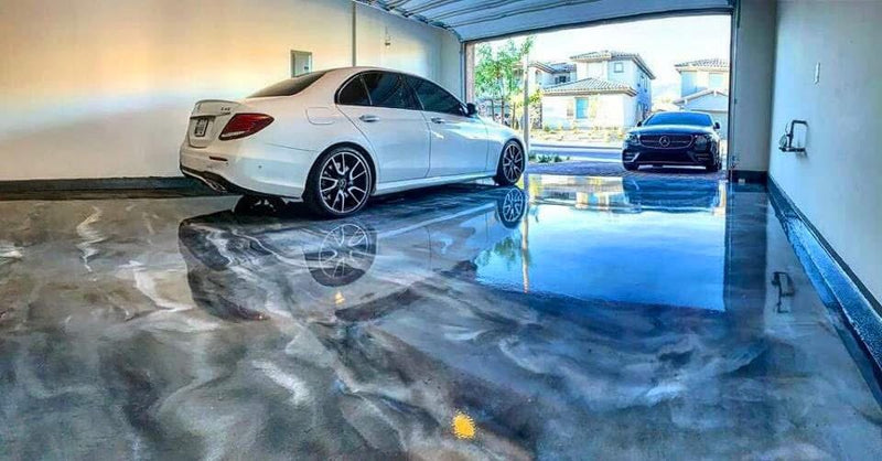 Silver metallic epoxy garage floor with two Mercedes-Benz sedans