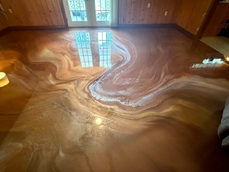 Copper and bronze marbled metallic epoxy floor in a wood-paneled room