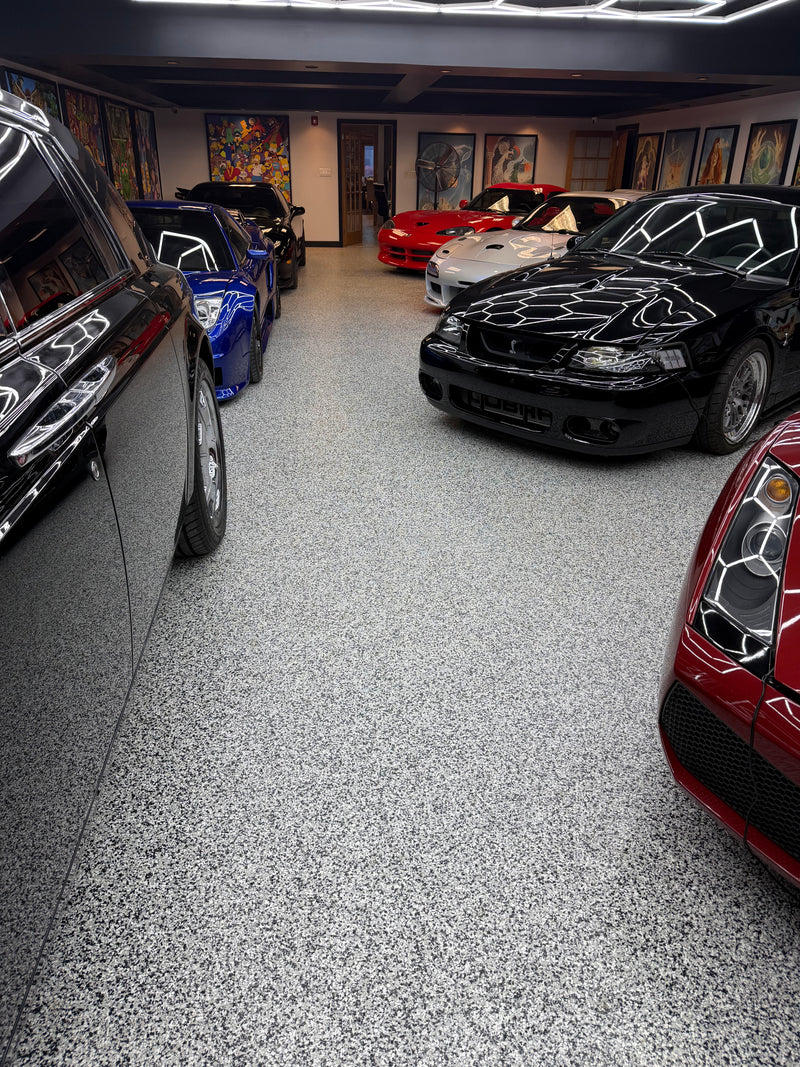 Gray flake epoxy showroom floor with a luxury sports car collection