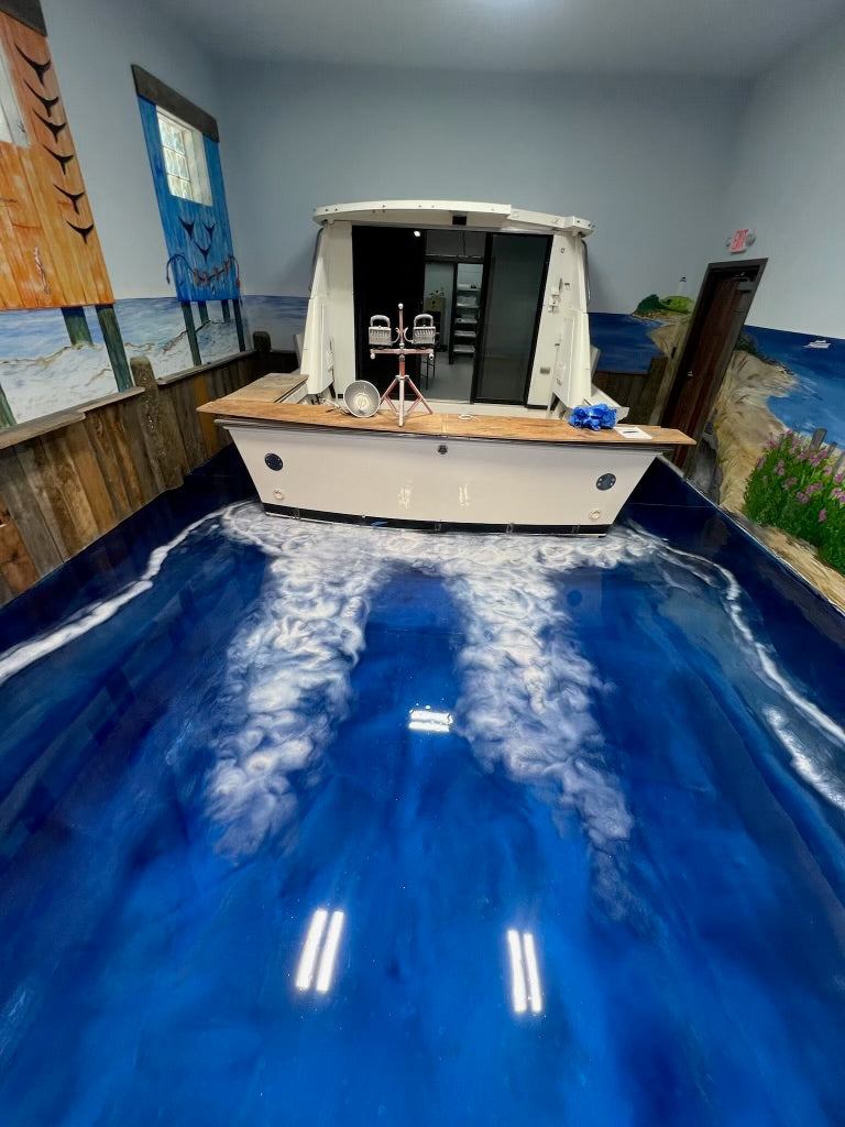 Blue ocean-themed epoxy floor with a boat and wake-pattern design