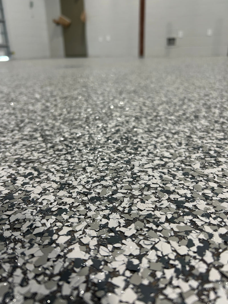 Close-up of gray, white and charcoal flake epoxy garage floor